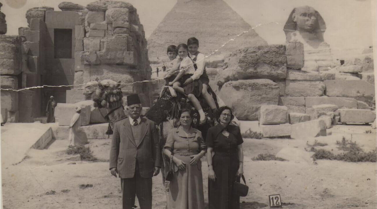 נונו ונונה סידס, הבת ז'אן, על הגמל הנכדים ריקו, טוני ובני. ברקע משמאל מצרים מקומיים, פירמידות, גיזה, מצרים, מתוך האלבום המשפחתי, 1952-5.